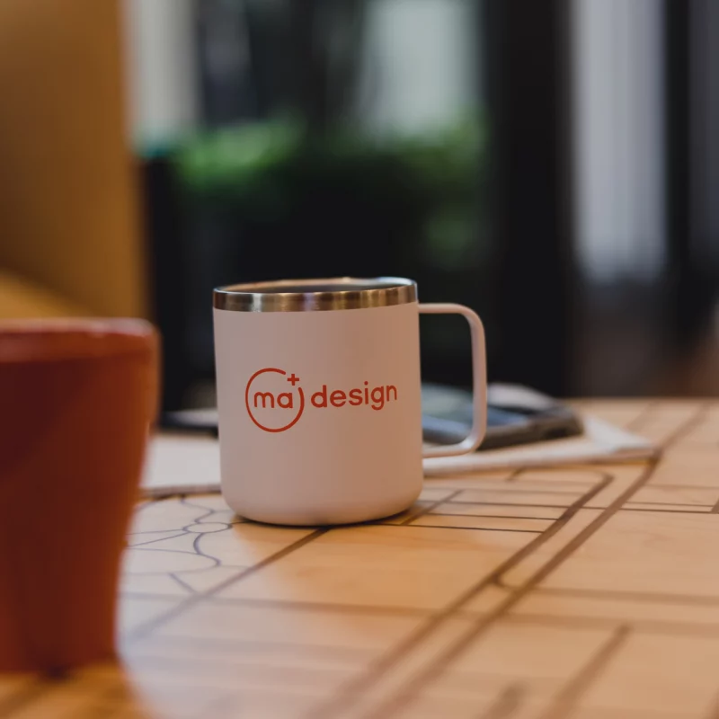 MA Design branded coffee mug on table