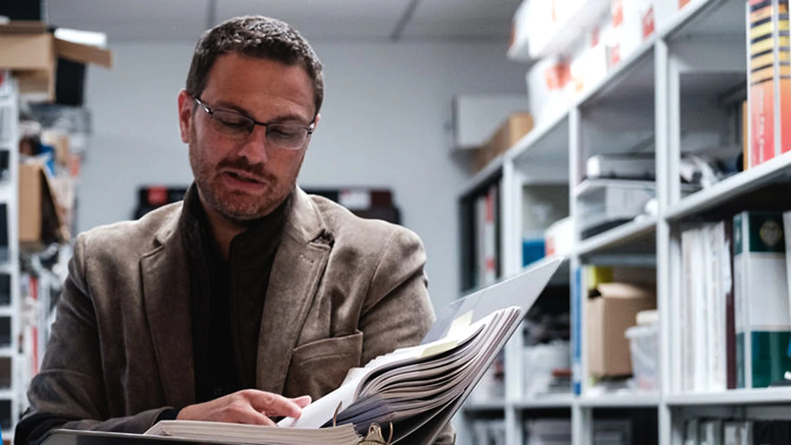 Kurt Beres looking at a code book open in his hands.
